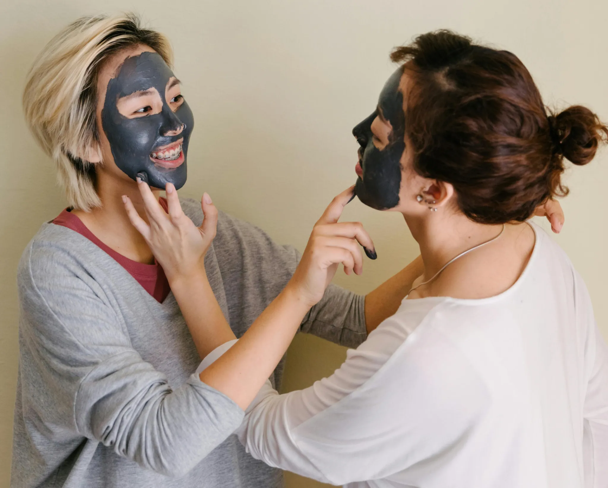 Two girls applying clay masks to each other's faces | Shine Dermatology